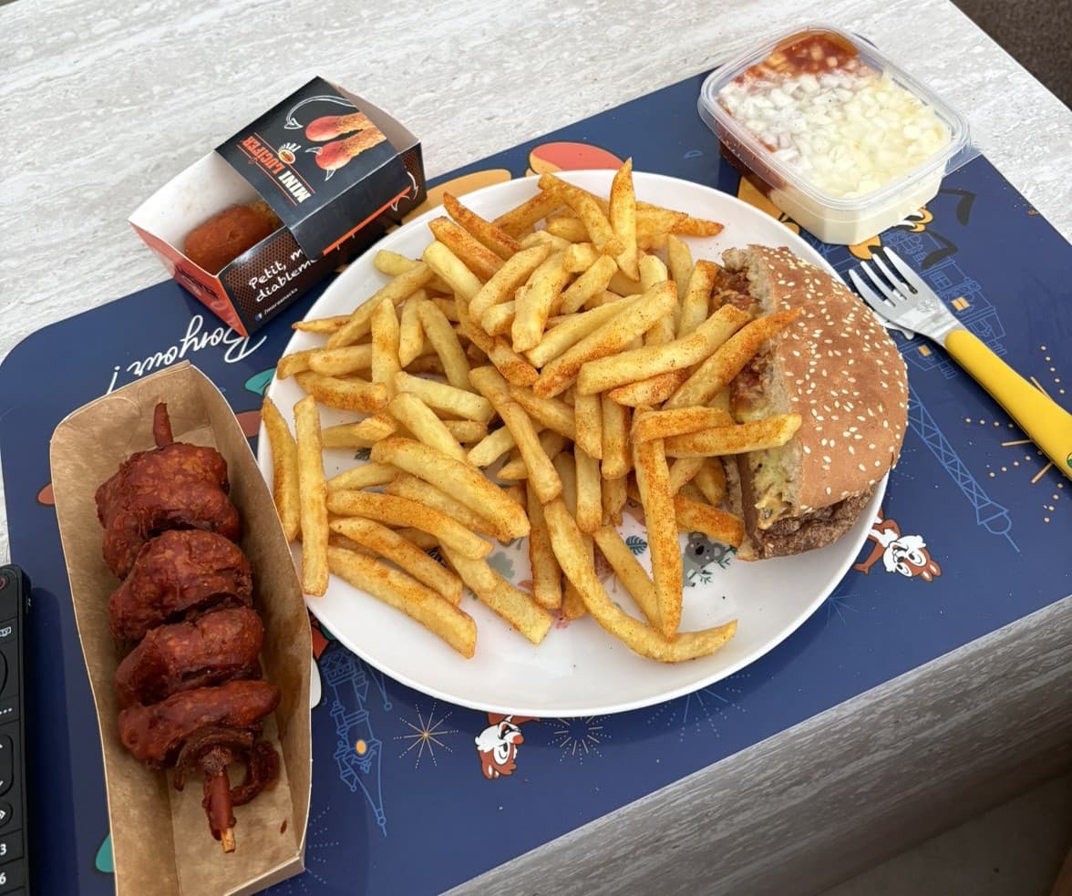 Bord met friet, burger en brochette op een blauw placemat